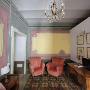 two pink chairs in the sitting room in the hotel 
