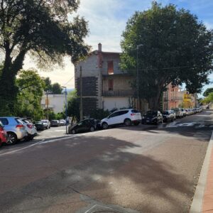2 cars parked on an inclined squeezed one behind the other